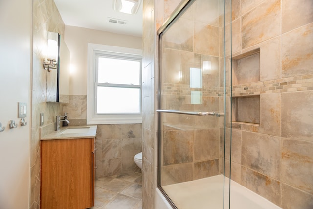 2900 W Birchwood Ave, Chicago, IL 60645 - bathroom featuring vanity, a tile shower, tile walls, and tile patterned floors