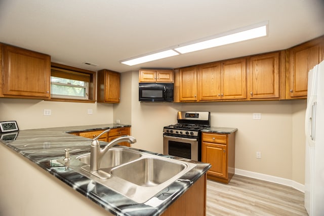 2900 W Birchwood Ave, Chicago, IL 60645 - kitchen with black microwave, stainless steel gas range, brown cabinets, light wood-type flooring, and white refrigerator with ice dispenser