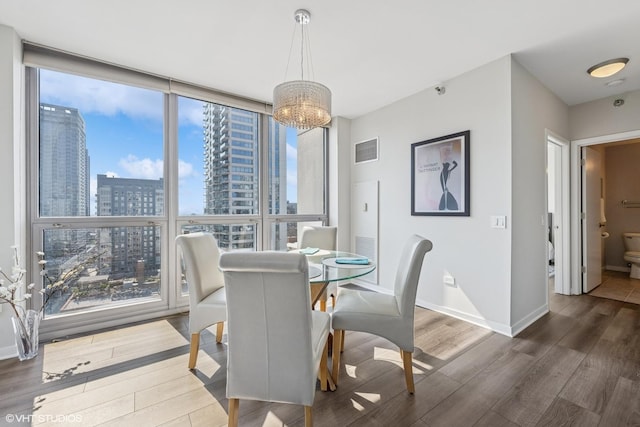 200 W Grand Ave Unit 1803, Chicago, IL 60654 - dining room with wood finished floors, a city view, expansive windows, and a chandelier