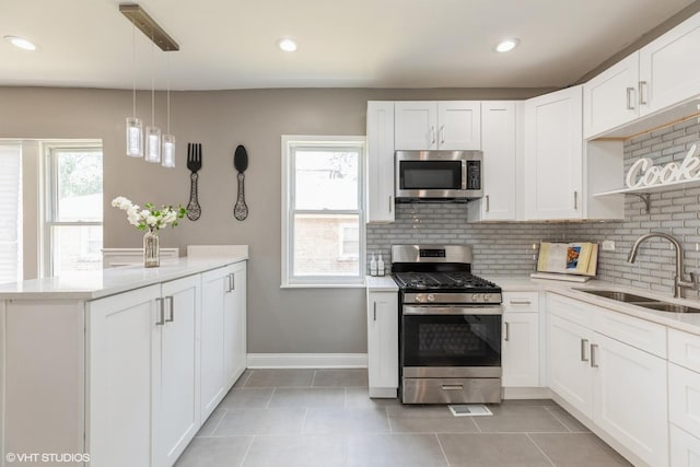12330 S Perry Ave, Chicago, IL 60628 - kitchen with stainless steel appliances, decorative backsplash, a peninsula, white cabinets, and recessed lighting