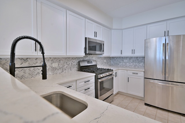 111 N Larch Ave Unit 206, Elmhurst, IL 60126 - kitchen featuring appliances with stainless steel finishes, light tile patterned floors, white cabinetry, and decorative backsplash