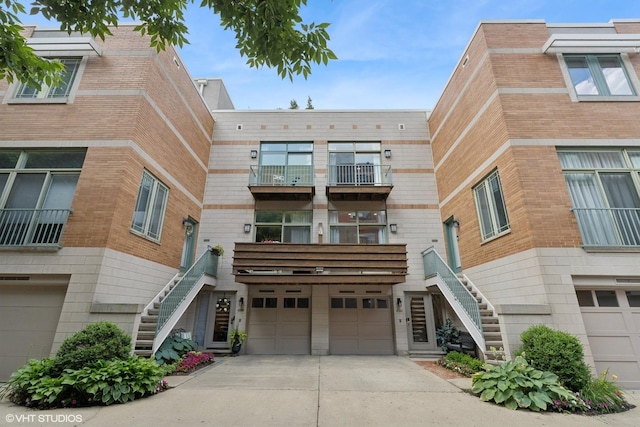 1401 N Wieland St Unit P, Chicago, IL 60610 - view of building exterior with stairway, a garage, and concrete driveway