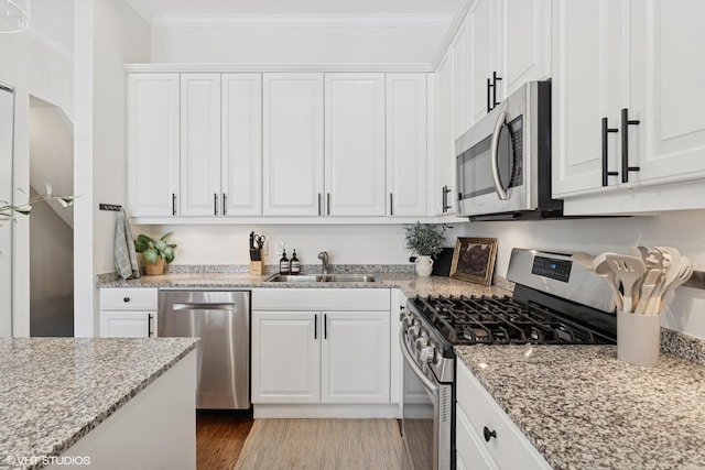1401 N Wieland St Unit P, Chicago, IL 60610 - kitchen featuring stainless steel appliances, white cabinetry, light wood-style flooring, and ornamental molding
