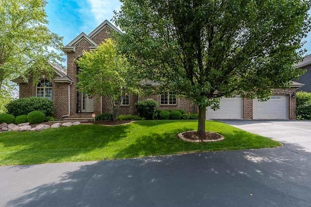 12499 Ayrshire Ln, Loves Park, IL 61111 - obstructed view of property with asphalt driveway, brick siding, a front yard, and a garage
