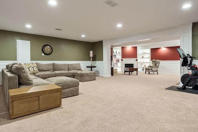 12499 Ayrshire Ln, Loves Park, IL 61111 - carpeted living area with a decorative wall, a fireplace, recessed lighting, built in shelves, and a wainscoted wall