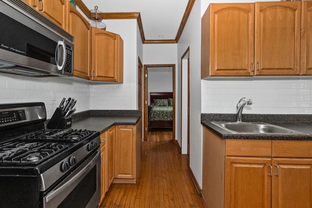 510 Madison St Unit 3S, Oak Park, IL 60302 - kitchen with appliances with stainless steel finishes, crown molding, dark countertops, dark wood-type flooring, and tasteful backsplash