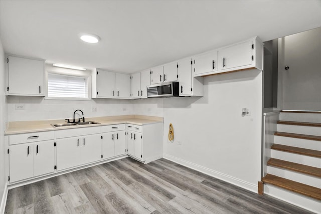 5809 W 90th Pl, Oak Lawn, IL 60453 - kitchen featuring stainless steel microwave, light wood finished floors, white cabinetry, and light countertops