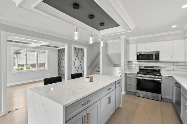 5809 W 90th Pl, Oak Lawn, IL 60453 - kitchen featuring stainless steel appliances, gray cabinetry, light stone counters, crown molding, and light wood-style flooring