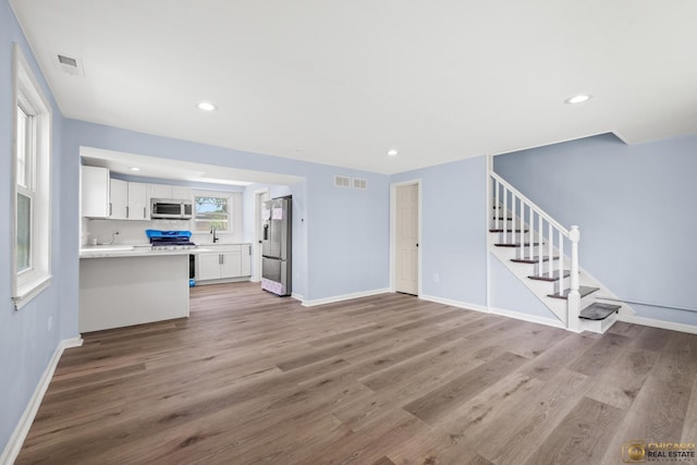9509 S Merrion Ave, Chicago, IL 60617 - unfurnished living room featuring stairway, light wood-style flooring, and recessed lighting
