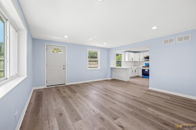 9509 S Merrion Ave, Chicago, IL 60617 - unfurnished living room featuring light wood-style flooring and recessed lighting