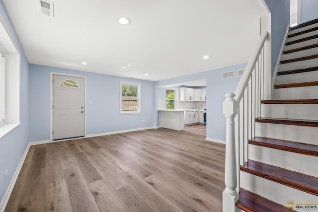 9509 S Merrion Ave, Chicago, IL 60617 - unfurnished living room with stairway, light wood-style floors, and recessed lighting