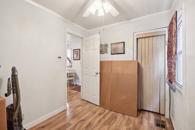 4842 S Wallace St, Chicago, IL 60609 - bedroom with light wood-type flooring, ornamental molding, multiple windows, a ceiling fan, and a closet