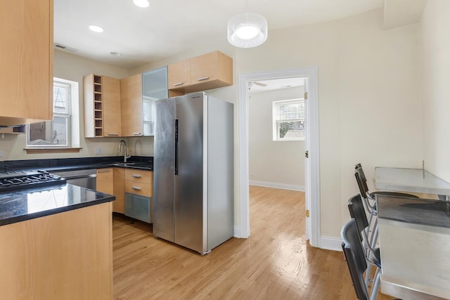 3415 W Berteau Ave Unit 1, Chicago, IL 60618 - kitchen featuring appliances with stainless steel finishes, light brown cabinetry, dark countertops, light wood-type flooring, and decorative light fixtures