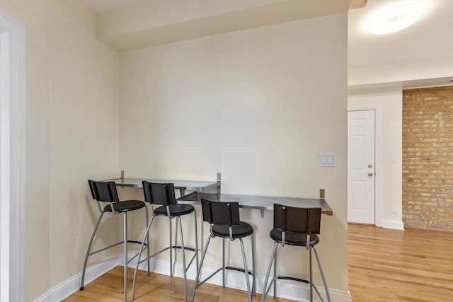 3415 W Berteau Ave Unit 1, Chicago, IL 60618 - dining area with light wood finished floors and brick wall