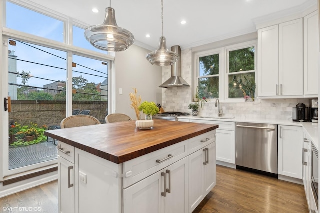 1212 W School St, Chicago, IL 60657 - kitchen with stainless steel dishwasher, butcher block countertops, wall chimney range hood, tasteful backsplash, and recessed lighting