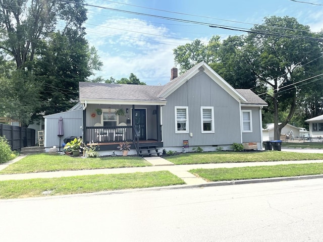 512 Seminary Ave, Bloomington, IL 61701 - view of front facade featuring covered porch, a front yard, and a chimney
