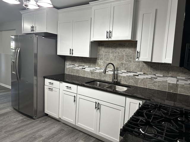 207 W 2nd St, Streator, IL 61364 - kitchen with stainless steel fridge, light wood-style flooring, white cabinetry, dark stone countertops, and backsplash