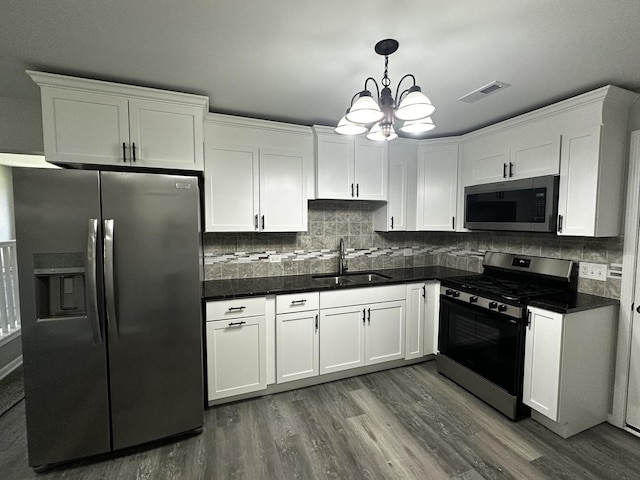 207 W 2nd St, Streator, IL 61364 - kitchen with appliances with stainless steel finishes, dark countertops, dark wood-type flooring, and white cabinets