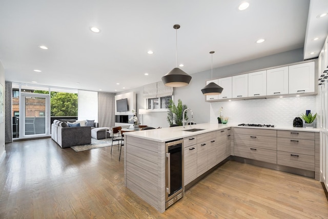927 N Damen Ave Unit 2, Chicago, IL 60622 - kitchen featuring wine cooler, a peninsula, gas cooktop, decorative backsplash, and open floor plan