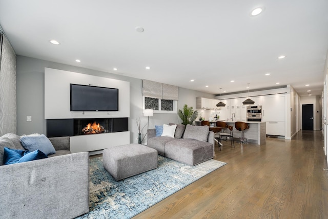 927 N Damen Ave Unit 2, Chicago, IL 60622 - living room featuring recessed lighting, wood finished floors, and a warm lit fireplace