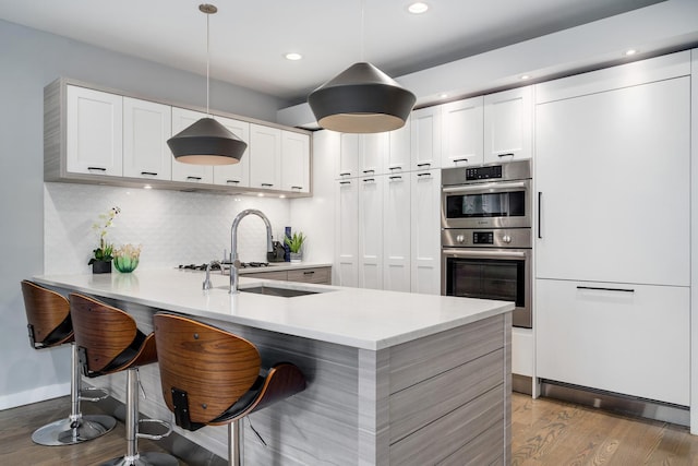 927 N Damen Ave Unit 2, Chicago, IL 60622 - kitchen featuring double oven, wood finished floors, light countertops, a peninsula, and recessed lighting