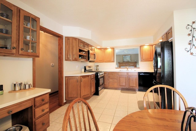 396 W 8th St, Manteno, IL 60950 - kitchen featuring black appliances, light tile patterned floors, glass insert cabinets, light countertops, and brown cabinets