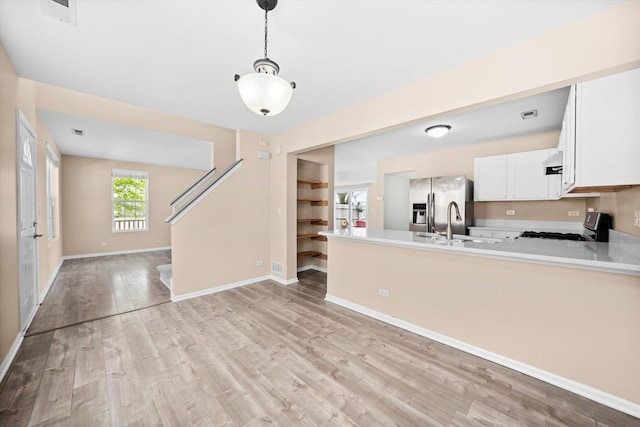 995 Serendipity Dr, Aurora, IL 60504 - kitchen featuring gas range, light wood-style floors, a peninsula, white cabinetry, and light countertops