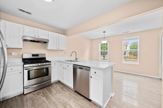 995 Serendipity Dr, Aurora, IL 60504 - kitchen featuring stainless steel appliances, under cabinet range hood, a peninsula, light countertops, and light wood-style floors