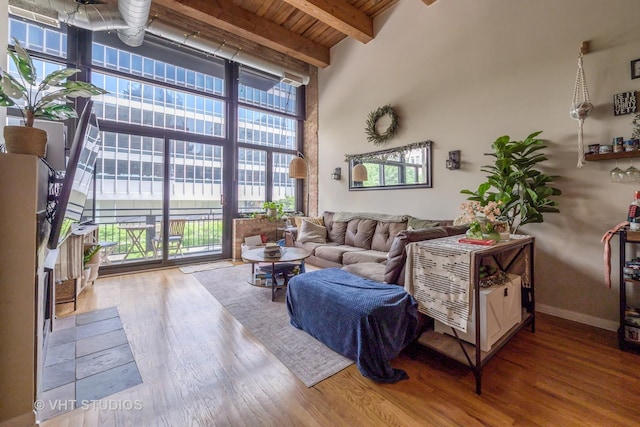 525 W Superior St Unit 224, Chicago, IL 60654 - living area featuring healthy amount of natural light, a high ceiling, a wall of windows, wood finished floors, and a wooden ceiling with exposed beams