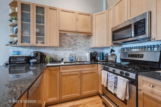 525 W Superior St Unit 224, Chicago, IL 60654 - kitchen featuring stainless steel appliances, decorative backsplash, dark stone counters, and glass insert cabinets