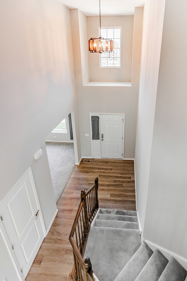 241 Stonington Dr, Bloomingdale, IL 60108 - stairs with wood finished floors, a chandelier, and a high ceiling