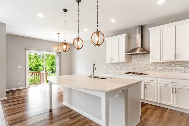 241 Stonington Dr, Bloomingdale, IL 60108 - kitchen featuring wall chimney range hood, a kitchen island with sink, tasteful backsplash, wood finished floors, and recessed lighting
