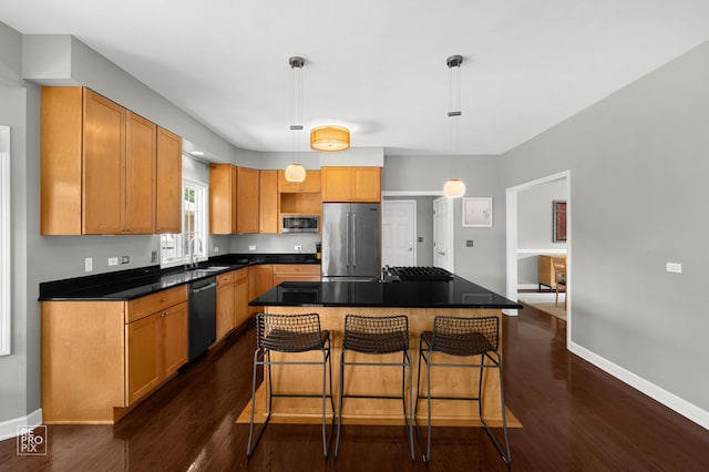 100 Homestead Dr, Wood Dale, IL 60191 - kitchen featuring appliances with stainless steel finishes, dark countertops, a breakfast bar, and dark wood-style flooring