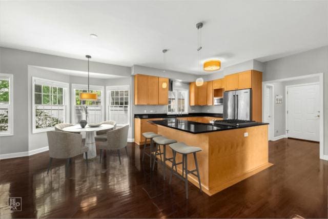 100 Homestead Dr, Wood Dale, IL 60191 - kitchen with freestanding refrigerator, a center island, dark wood-type flooring, dark countertops, and hanging light fixtures