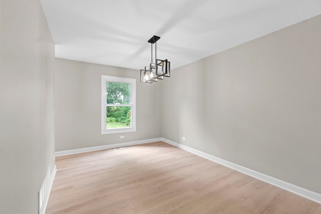 341 Tanager Dr, Woodstock, IL 60098 - spare room featuring a chandelier and light wood-style floors