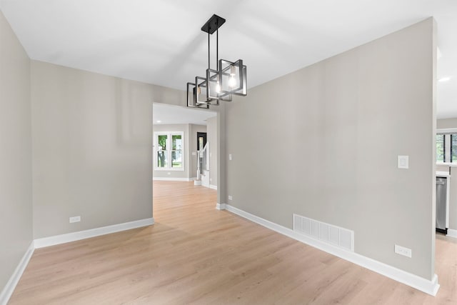 341 Tanager Dr, Woodstock, IL 60098 - unfurnished room featuring a chandelier and light wood-type flooring