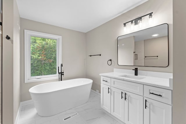 341 Tanager Dr, Woodstock, IL 60098 - bathroom featuring marble look tiles, vanity, and a freestanding tub