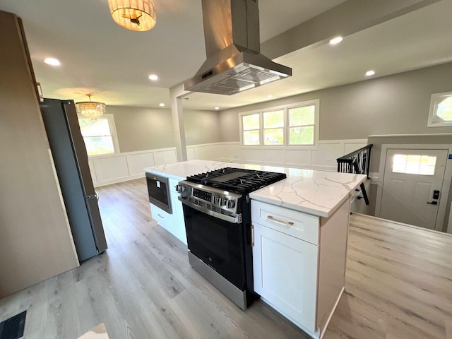 1813 218th Pl, Sauk Village, IL 60411 - kitchen with stainless steel appliances, island exhaust hood, wainscoting, white cabinetry, and light stone countertops