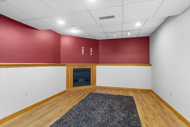 963 S Trainer Rd, Rockford, IL 61108 - spare room with wood finished floors, a paneled ceiling, a glass covered fireplace, and recessed lighting