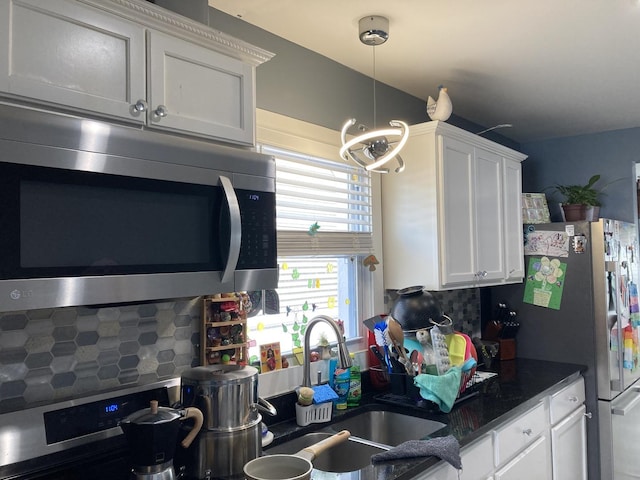 7814 S Trumbull Ave, Chicago, IL 60652 - kitchen featuring appliances with stainless steel finishes, decorative backsplash, white cabinetry, and pendant lighting