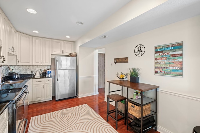 1777 W Crystal Ln Unit 711, Mount Prospect, IL 60056 - kitchen featuring stainless steel appliances, dark wood finished floors, dark countertops, backsplash, and white cabinetry