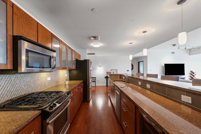 301 N Neil St Unit 609, Champaign, IL 61820 - kitchen featuring appliances with stainless steel finishes, dark wood-style floors, decorative backsplash, and dark stone countertops