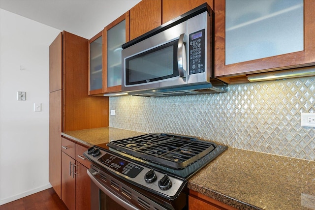 301 N Neil St Unit 609, Champaign, IL 61820 - kitchen featuring appliances with stainless steel finishes, glass insert cabinets, dark wood-style flooring, brown cabinetry, and tasteful backsplash