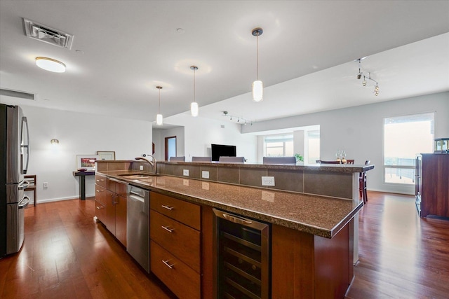 301 N Neil St Unit 609, Champaign, IL 61820 - kitchen featuring beverage cooler, stainless steel appliances, track lighting, a large island, and dark wood finished floors