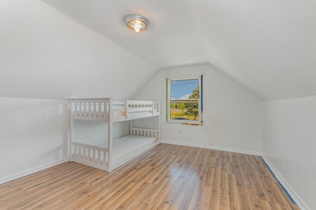 7900 S 86th Ct, Justice, IL 60458 - unfurnished bedroom featuring wood finished floors and vaulted ceiling