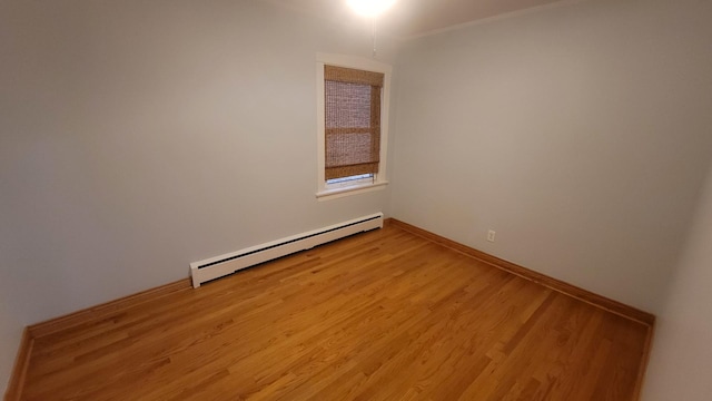 5448 W Agatite Ave, Chicago, IL 60630 - empty room with a baseboard heating unit and light wood-type flooring