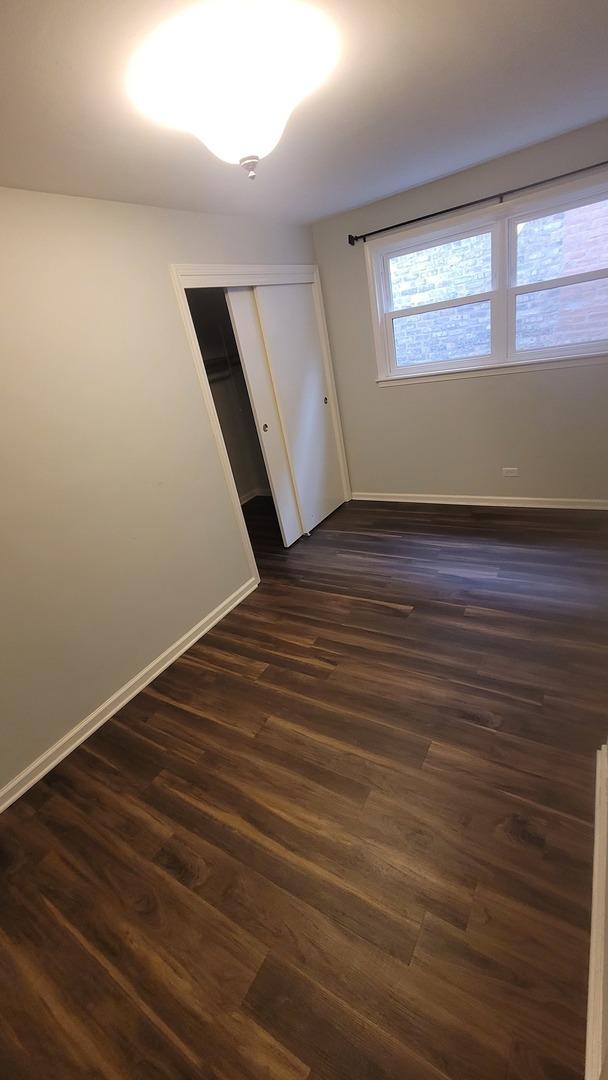 5448 W Agatite Ave, Chicago, IL 60630 - empty room with baseboards and dark wood-style floors
