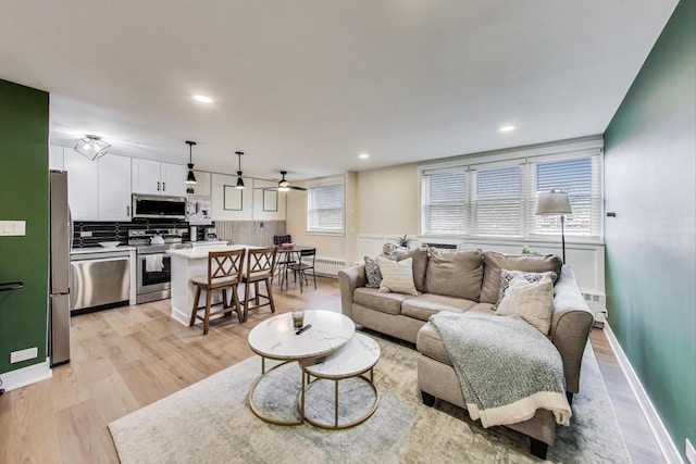 1333 W Touhy Ave Unit 102, Park Ridge, IL 60068 - living room featuring light wood-style flooring, ceiling fan, recessed lighting, radiator heating unit, and a baseboard radiator