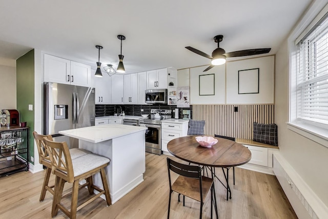 1333 W Touhy Ave Unit 102, Park Ridge, IL 60068 - kitchen featuring stainless steel appliances, light wood-style flooring, white cabinetry, and decorative backsplash