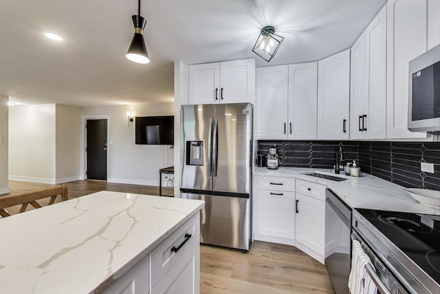 1333 W Touhy Ave Unit 102, Park Ridge, IL 60068 - kitchen with appliances with stainless steel finishes, backsplash, light wood-type flooring, and white cabinetry